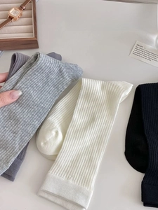 Close-up of combed cotton ribbed socks in black, white, and grey with soft texture