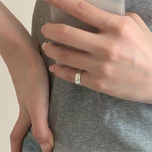 Close-up of a silver minimalist heart ring worn on a hand in a mirror selfie style