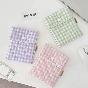Close-up of quilted gingham storage bags in purple, green, and pink with button closure