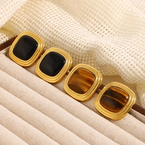 Detailed macro of 18K gold plated square stud earrings with tiger eye and black stone