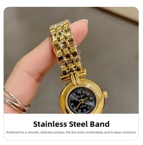 Macro detail of a women gold stainless steel quartz watch with black Roman numeral dial