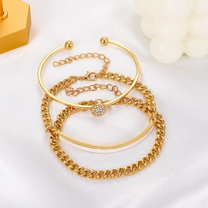 Detailed view of 3-piece gold bracelet set with zircon charm and white enamel finish