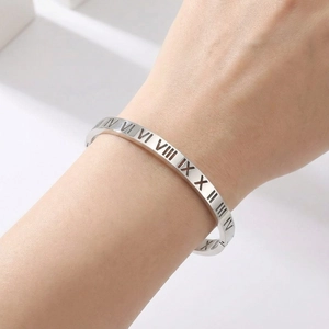 Minimalist silver hollow Roman numerals stainless steel bangle on model's wrist