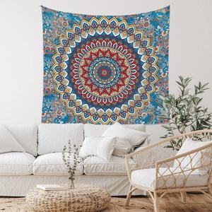Detail of blue and red bohemian mandala tapestry hung above a sofa in a cozy room