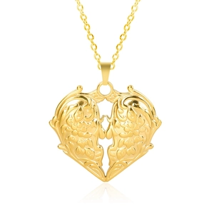 Gros plan d'un pendentif cœur doré avec gravure florale baroque et finition polie