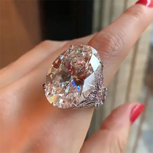 Classic oval-cut zircon ring with micro-pave setting on silver band worn by a model