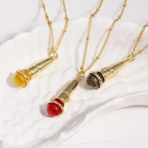 Detailed close-up of microphone pendants in gold, red, and bronze on bead chains