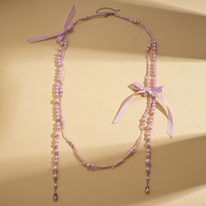 Collier de perles multicouche élégant avec nœuds en ruban violet et pendentifs en cristal