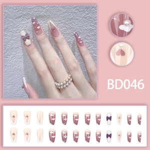 Detail of lavender and white press-on nails with 3D bows, pearls and cloud designs