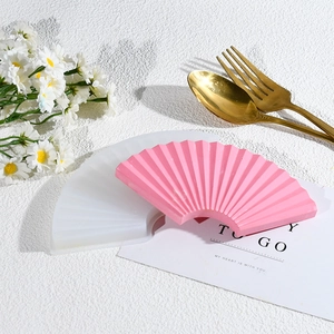Detailed fan-shaped silicone mold with finished resin coaster on a textured background