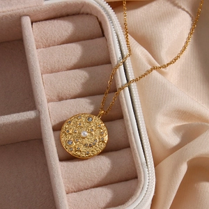 Collana con medaglia celeste dorata con ciondoli stella e luna su seta morbida