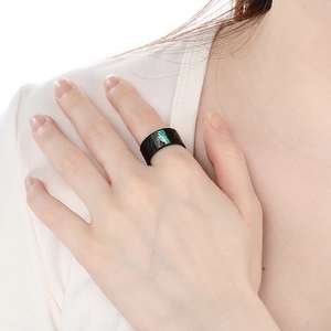 Detail view of a black hammered stainless steel ring with rectangular abalone shell inlay