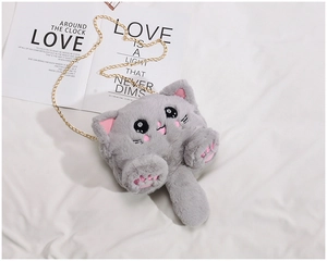 Close-up of cute grey plush cat bag with soft fur texture and golden metal chain strap