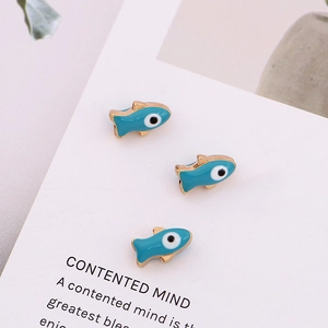 Three blue fish evil eye enamel charms for DIY jewelry making on a white card