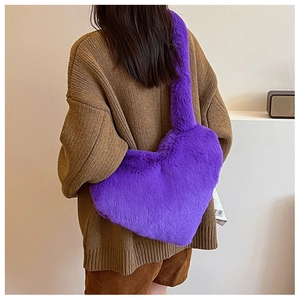 Woman in casual attire wearing a purple heart-shaped plush faux fur shoulder bag