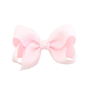 Detailed view of pink grosgrain ribbon bow hair clip with textured ribbed fabric finish