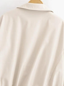 Detail of beige faux leather jacket back hanging on a wooden hanger with smooth texture