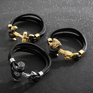 Macro view of multi-layer braided leather bracelets with anchor and compass metal charms