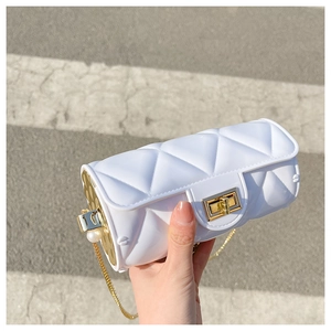 Close-up of white cylindrical jelly bag featuring quilted pattern and golden chain strap