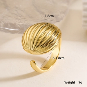 Close-up of golden geometric shell texture ring with adjustable open band detail