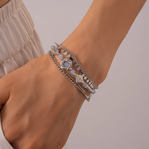 Detail shot of multi-layer silver bracelet with pale blue beads and textured metal charms