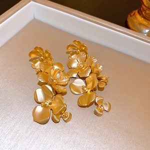 Detail of elegant champagne gold floral tassel earrings on a premium jewelry box edge