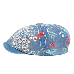 Close-up of blue denim newsboy cap featuring detailed floral embroidery and pattern
