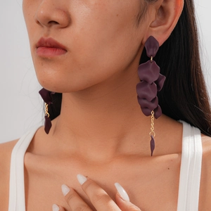 Close-up of purple acrylic petal tassel earrings with gold chain on model neck