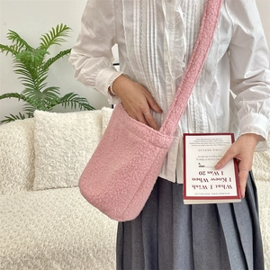 Détail du sac seau en peluche rose avec bandoulière large en fausse fourrure style mouton
