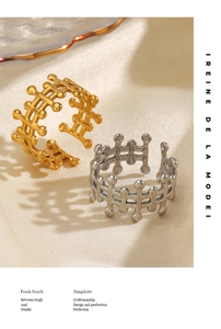 Detailed view of adjustable gold and silver lattice rings on soft satin fabric background