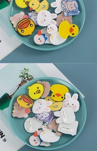 Macro shot of cute acrylic cartoon animal pins including yellow duck and rabbit motifs