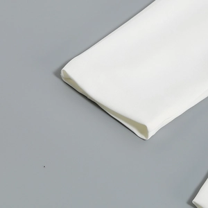 Close-up of white twill fabric texture and professional cuff detail on a women's suit jacket