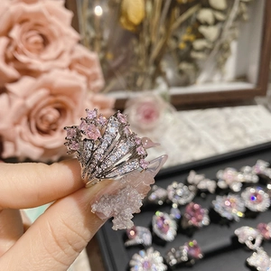 Detailed close-up of a wide silver ring featuring radiant pink heart and white gemstones