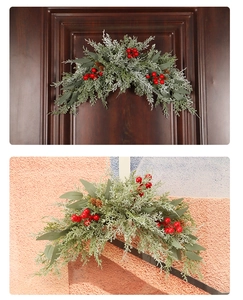 Detail of Christmas PE red berry garland with frosted green leaves and pinecones on a door