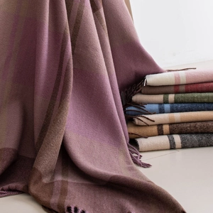 Pink and purple plaid scarf with tassels shown with a variety of colorful tartan shawls