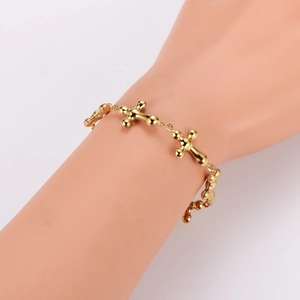Polished gold stainless steel cross link bracelet on a wrist with a minimalist look