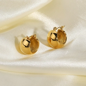 Polished 18K gold plated stainless steel dome hoop earrings on cream satin fabric
