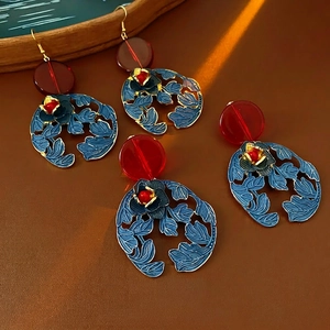 Vintage hollow flower drop earrings with red beads and blue floral discs on leather