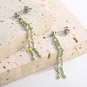 Minimalist silver chain tassel earrings with vibrant neon yellow dot accents on stone