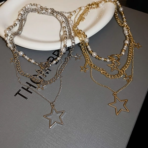 Detailed close-up of layered pearl necklaces with star pendants in gold and silver finish