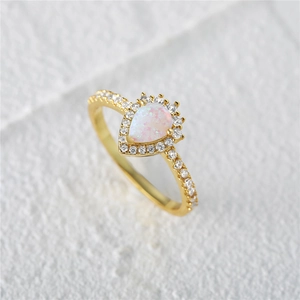 Macro shot of gold pear-cut opal ring featuring shimmering accent crystals in high detail