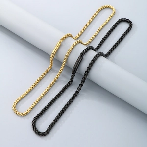 Detailed view of woven stainless steel chain necklaces in gold and black with spring clasp
