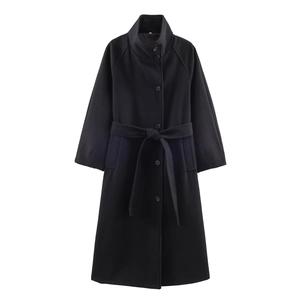 Detailed view of women's long black wool coat with tie waist belt and button closure