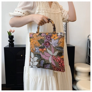 Detailed embroidery and sequins floral patterns on linen handbag with bamboo handle