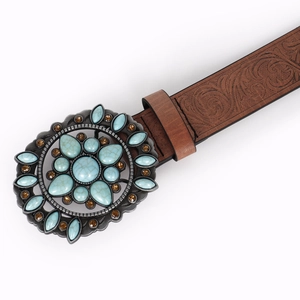 Detail showing vintage brown belt with embossed floral pattern and turquoise buckle