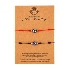 Dettaglio dei braccialetti portafortuna a 7 nodi intrecciati rossi e neri con Evil Eye