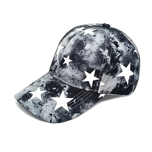 Detail view of tie-dye baseball cap featuring white star patterns and curved brim