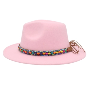 Détail du chapeau fedora rose clair avec ruban ethnique tissé et perles de bois