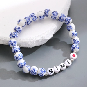 Dettaglio di perle in ceramica blu e bianche con lettere MIMI sul braccialetto