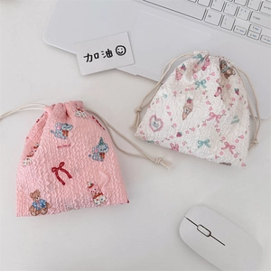 Detail of cute bubble fabric drawstring bags in pink and cream with cartoon patterns